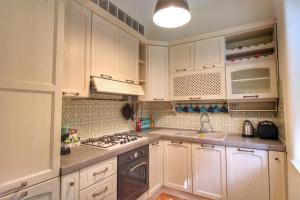 a kitchen with white cabinets and a stove top oven at Charming Vatican LargeApt by YH in Rome