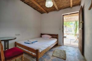 a bedroom with a bed and a table and a window at Gabriellas Garden in Palaiokastro