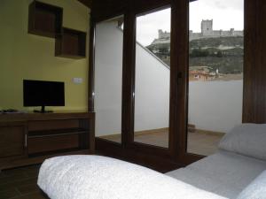 佩納菲爾的住宿－Apartamentos Turísticos Peñafiel，一间卧室设有享有城堡景致的窗户。
