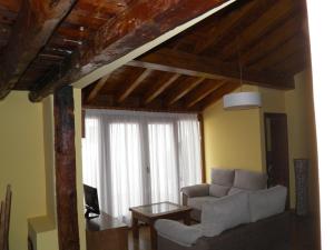 a living room with a couch and a window at Apartamentos Turísticos Peñafiel in Peñafiel