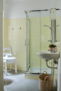 a bathroom with a shower and a sink and a chair at Succeed Campo Pequeno Guest House in Lisbon