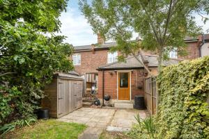 a brick house with a orange door and a fence at 3BR house a perfect group getaway in London