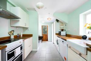 a kitchen with white cabinets and a sink at 3BR house a perfect group getaway in London