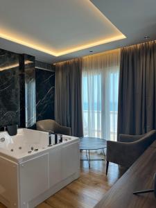 sala de estar con bañera y mesa en Klajdi Resort & SPA, en Golem