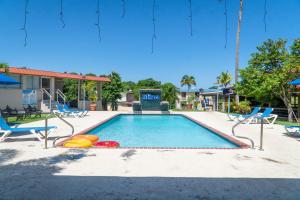 a swimming pool with chairs and a playground at Parador El Faro in Aguadilla