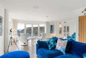 sala de estar con sofá azul y mesa en The Lookout, en Portreath
