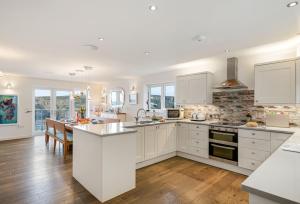 a kitchen with white cabinets and a kitchen island at The Lookout in Portreath