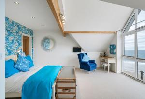 1 dormitorio con cama, escritorio y ventana en The Lookout, en Portreath