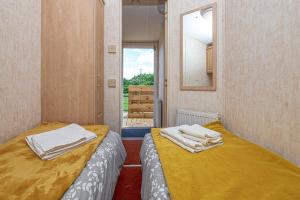 2 camas en una habitación pequeña con ventana en Caravan at Ysgubor, en Tregarth