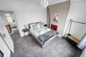 a bedroom with a bed in a white room at Stylish Home - Fast Wi-Fi-FREE Parking in Nottingham