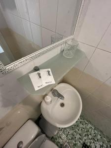 a bathroom with a sink and a toilet and a mirror at True Man Beach Apartments in Odesa