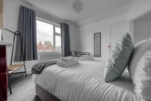 a bedroom with a large white bed with a window at Stylish Home - Fast Wi-Fi-FREE Parking in Nottingham