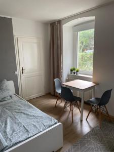 a bedroom with a bed and a table and chairs at Einfaches Appartement "Hannes" in Halle in Kröllwitz