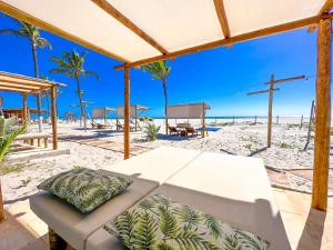 un banco en la playa con vistas a la playa en Jangadeiro Praia Hotel Resort - Pé na Areia en Aquiraz