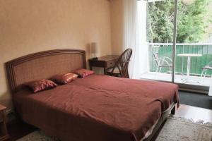 ein Schlafzimmer mit einem großen Bett und einem Balkon in der Unterkunft Cosy cocoon with terrace near the sea in Arcachon