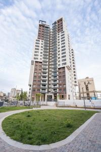 two tall buildings in a city with a grass field at luxury studio flat in Jerusalem