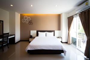 a bedroom with a bed and a large window at Phavina Hotel Rayong SHA Extra Plus in Rayong