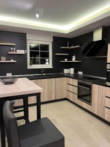 a kitchen with black walls and a table and a window at Villa Aida in Sarajevo