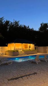 a building with a swimming pool at night at Villa Aida in Sarajevo