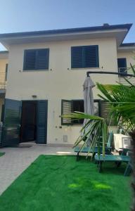 錫羅洛的住宿－Casa Mia Sirolo，一座带遮阳伞的绿色庭院