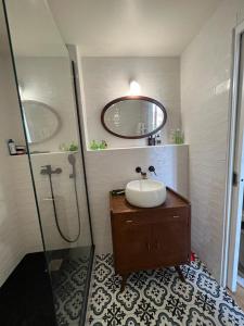 a bathroom with a sink and a shower with a mirror at Calme & jolie maison près de Paris in Nanterre