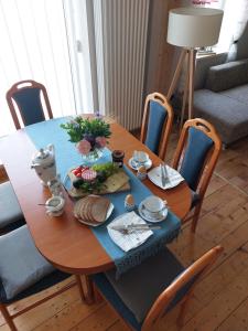 une table en bois avec un chiffon de table bleu et de la nourriture dans l'établissement Stilvolle Ferienwohnung im Eichsfeld, à Niederorschel