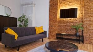 a living room with a couch and a brick wall at ATF Apartments in Riga