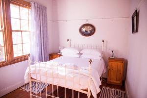 1 dormitorio con cama blanca y ventana en Oasis en Nieu-Bethesda