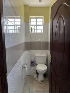 a bathroom with a toilet and a window at Eclectic 2 bedrm homely & comfy in Machakos