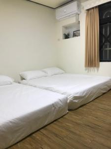 2 letti posti uno accanto all'altro in una stanza di Starry Sky Hostel a Checheng