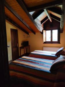 a bedroom with a large bed in a attic at Hotel Doña Gaudiosa in Pola de Lena