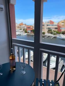 een fles wijn op een tafel op een balkon bij Studio cabine barcares in Le Barcarès