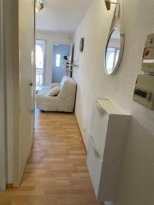 a room with a hallway with a couch and a mirror at Studio cabine barcares in Le Barcarès