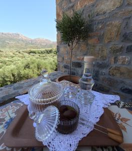 einen Tisch mit Brille und eine Flasche auf dem Tisch in der Unterkunft Stone House in Sitia