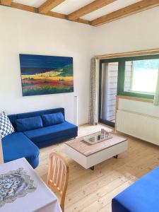 sala de estar con sofá azul y mesa en Apartment Steinwänd Top 8, en Grünau im Almtal