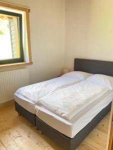 a large bed in a bedroom with a window at Apartment Steinwänd Top 8 in Grünau im Almtal