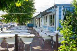 eine Reihe von Tischen und Stühlen auf einer Terrasse in der Unterkunft slube am Yachthafen Greifswald in Greifswald