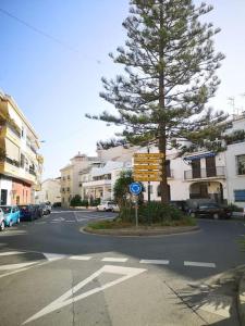 a tree on the side of a street with a sign at Apartamento Tropical by Bossh! Apartments in Salobreña
