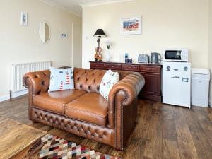 un sofá de cuero marrón en la sala de estar en The Retreat @ Wolds View, en Bridlington