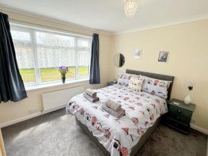 1 dormitorio con cama y ventana grande en The Retreat @ Wolds View, en Bridlington