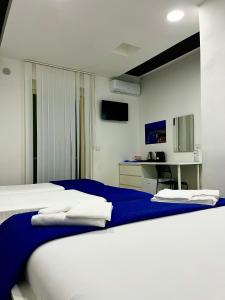 a bedroom with a bed with blue and white sheets at Pompei Art in Scafati