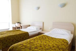 a hotel room with two beds with yellow blankets at LUNA Marijampole in Marijampolė