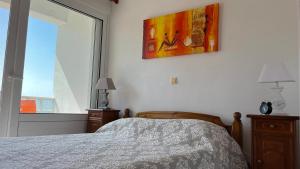 1 dormitorio con 1 cama y una pintura en la pared en Kagiabis' Home, en Gouves
