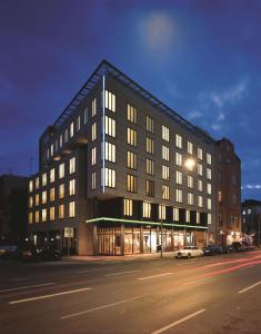 een groot zwart gebouw in een stadsstraat 's nachts bij Park Plaza Berlin in Berlijn