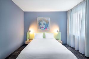 ein großes weißes Bett in einem Zimmer mit blauen Wänden in der Unterkunft Park Plaza Berlin in Berlin + 37 Fotos