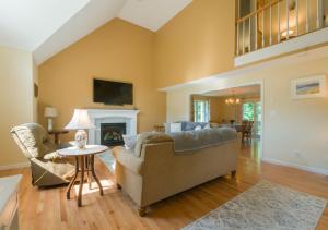 Una sala de estar con un sofá y una chimenea. en 132 Hooppole Road Mashpee Indra Cottage, en Mashpee