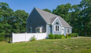 una casa azul con una valla blanca en un patio en 132 Hooppole Road Mashpee Indra Cottage, en Mashpee