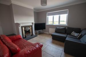 a living room with a couch and a fire place at Millbay View House in Kilkeel