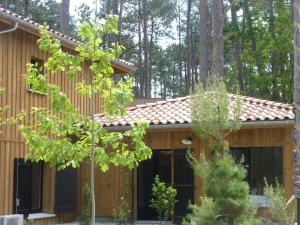 a wooden house with a red roof at Domaine du Ferret Restaurant & Spa in Cap-Ferret