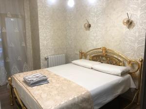 een slaapkamer met een wit bed met een gouden frame bij the best apartment in Koetaisi